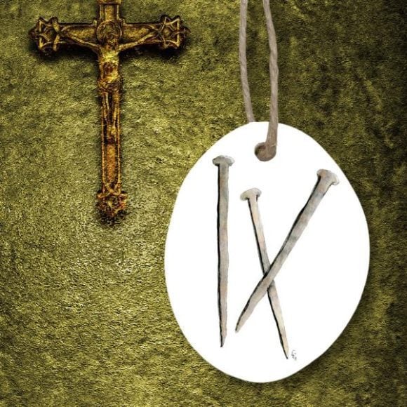 Three Nails Resurrection Easter Ornament on green background next to crucifix